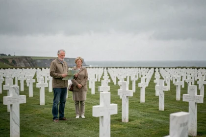 Couple de visiteurs se recueillant parmi les croix blanches du cimetière américain de Colleville-sur-Mer en Normandie