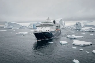 Le navire de croisière Ponant naviguant entre d'immenses icebergs en Antarctique