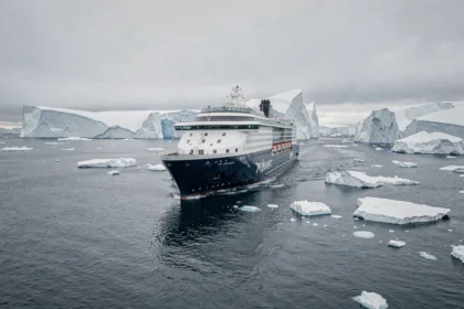 Le navire de croisière Ponant naviguant entre d'immenses icebergs en Antarctique