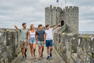 Famille se promenant sur les remparts médiévaux de Guérande en été, découvrant les tours historiques de la cité